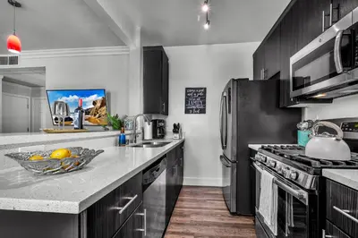 a kitchen with black cabinets and stainless steel appliances at Heart of La, Walk to everything!! in Los Angeles