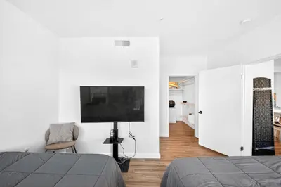 a bedroom with two beds and a tv on the wall at fusion hollywood in Los Angeles