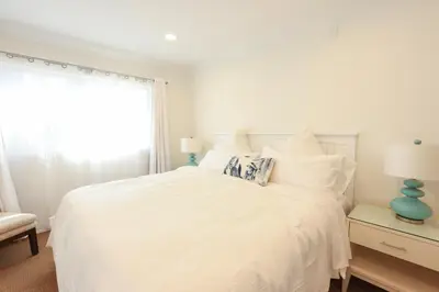 a white bedroom with a white bed and a window at SM ocean view in Los Angeles