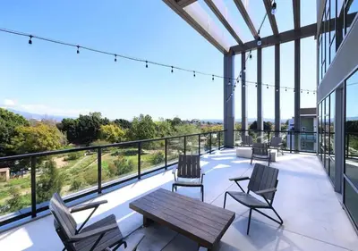 a patio with chairs and a wooden table on a balcony at New Oasis Near Disneyland Pool Gym Free Parking in Santa Ana