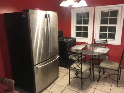 a kitchen with a stainless steel refrigerator and a table at Affordable Rooms in RV Trailer in Los Angeles