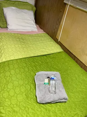 a bottle of water and a towel on a bed at Affordable Rooms in RV Trailer in Los Angeles
