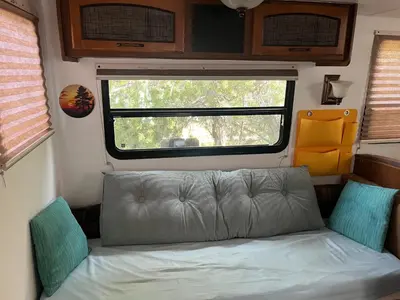a couch in an rv with a window at Comfortable Guest RV With EV charger Semi Rural Area in Bodfish