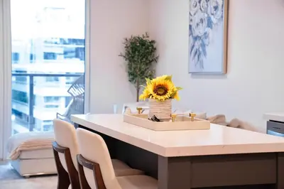 a dining room table with a sunflower in a vase at Elevated Escape Luxury 1BR in Hollywood in Los Angeles