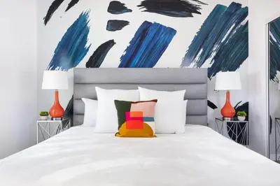 a bedroom with a white bed with colorful pillows at Upscale LA Getaway Sleeps 8 with Free Parking in Los Angeles