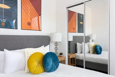 a bedroom with a bed with blue and yellow pillows at Upscale LA Getaway Sleeps 8 with Free Parking in Los Angeles