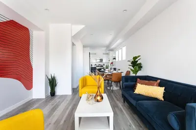 a living room with a blue couch and yellow chairs at Upscale LA Getaway Sleeps 8 with Free Parking in Los Angeles