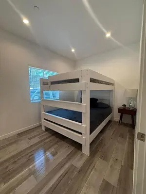 a bedroom with a white bunk bed and a wooden floor at Upscale LA Getaway Sleeps 8 with Free Parking in Los Angeles