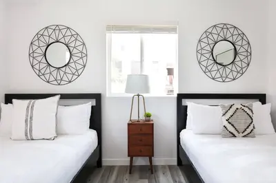 two beds in a bedroom with mirrors on the wall at Central 4BR Townhome Modern Perks in Los Angeles