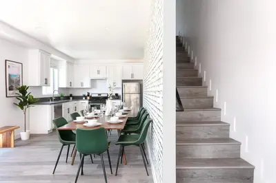 a dining room and kitchen with a table and green chairs at Spacious 4BR LA Getaway with Parking and Fast Wi-Fi in Los Angeles