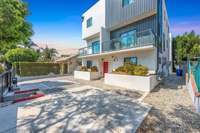 a large white building with a red door at Spacious 4BR LA Getaway with Parking and Fast Wi-Fi in Los Angeles