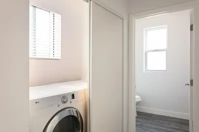 a white laundry room with a washer and dryer at 3BR Urban Retreat with Modern Amenities in Los Angeles