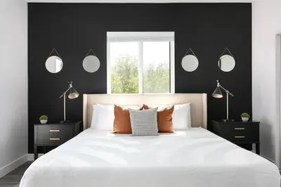 a bedroom with a white bed with black walls and mirrors at 3BR Urban Retreat with Modern Amenities in Los Angeles