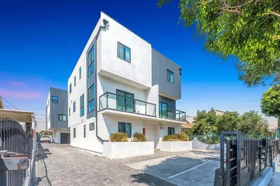 a white building with a fence in front of it at Spacious 5BR Townhouse with Free Parking Included in Los Angeles