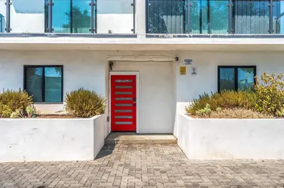 a red door on a white building with windows at Spacious 5BR Townhouse with Free Parking Included in Los Angeles