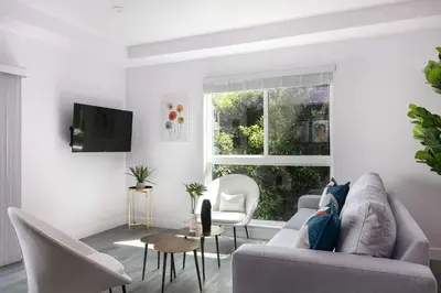 a white living room with a couch and a window at Spacious 5BR Townhouse with Free Parking Included in Los Angeles