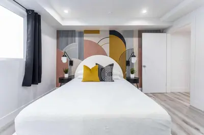 a bedroom with a large white bed with yellow pillows at Sunset Views from Private Rooftop in Luxe Townhome in Los Angeles