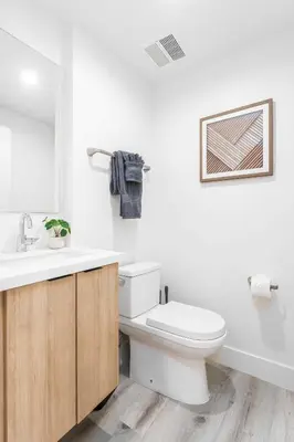 a white bathroom with a toilet and a sink at Sunset Views from Private Rooftop in Luxe Townhome in Los Angeles