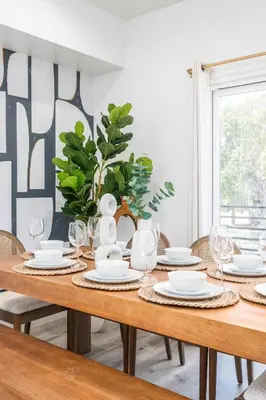 a dining room table with plates and wine glasses at Sunset Views from Private Rooftop in Luxe Townhome in Los Angeles
