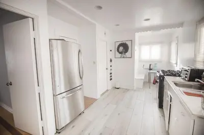 a kitchen with a stainless steel refrigerator and a wooden floor at Cozy room in East Holywood, 7 min from holllywood, 15 from downtown, 20 to hollywood sing in Los Angeles