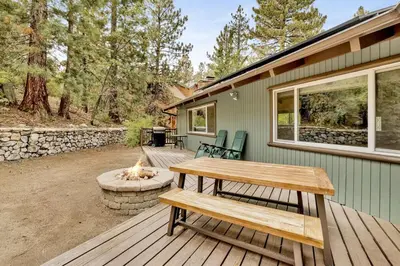 a wooden deck with a picnic table and a fire pit at Arlberg Village Haus Game Room Walk to the Slopes in Big Bear Lake