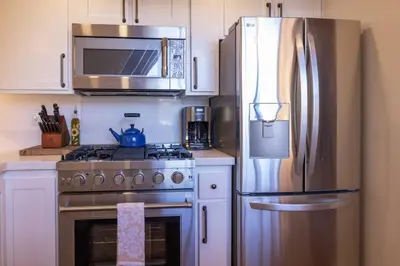 a kitchen with a stainless steel refrigerator and a stove at Cove Lakeside Jacuzzi, Central AC, Stunning View in Big Bear Lake