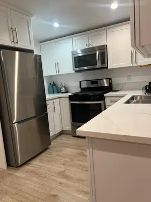a kitchen with white cabinets and a stainless steel refrigerator at Hanna's Corner in Canoga Park