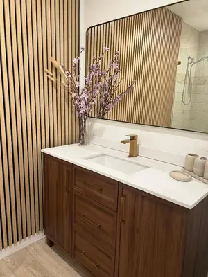 a bathroom with a sink and a vase of flowers at Hanna's Corner in Canoga Park