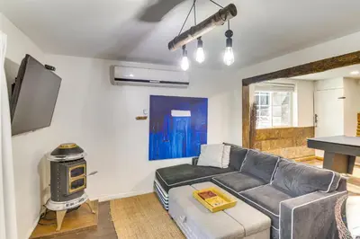 a living room with a couch and a flat screen tv at Golf and Swim! Pine Mtn Club Retreat with Game Area in Pine Mountain Club