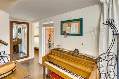 a piano in a living room with a room with a window at Golf and Swim! Pine Mtn Club Retreat with Game Area in Pine Mountain Club