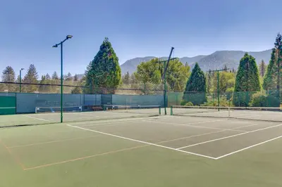 a tennis court with two tennis rackets on it at Golf and Swim! Pine Mtn Club Retreat with Game Area in Pine Mountain Club