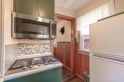 a kitchen with a stove with a microwave and a refrigerator at Dream Lake Cabin Spa, EV Charger, Gated, by lake! in Big Bear Lake