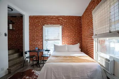 a bedroom with a bed and a brick wall at Modern Bachelor in Hollywood in Los Angeles