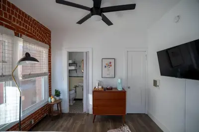a living room with a ceiling fan and a dresser at Modern Bachelor in Hollywood in Los Angeles