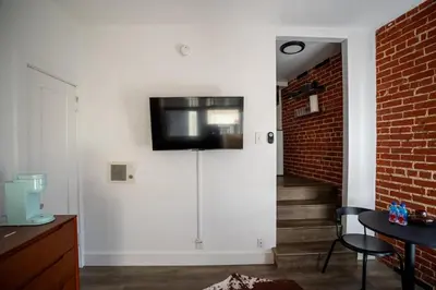 a living room with a tv on a white wall at Modern Bachelor in Hollywood in Los Angeles