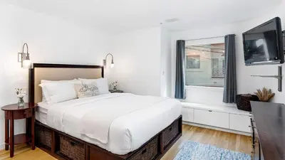 a white bedroom with a large bed and a window at Walk to Manhattan Beach Pier Ocean Views Balcony Peloton Casa Del Mar by AvantStay in Manhattan Beach