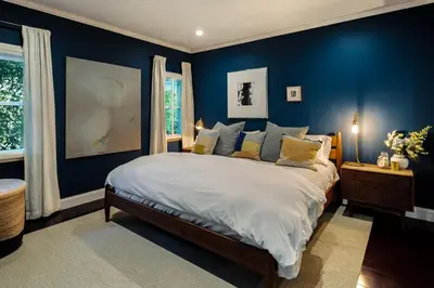 a bedroom with a large bed with blue walls at The Whitley Heights Sweet Escape With Jacuzzi and parking in Los Angeles
