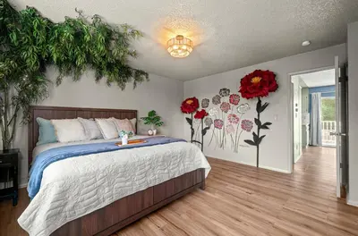 a bedroom with a bed with flowers on the wall at The Quirky Bloom-Whimsical Guest house in Upland