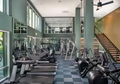 a gym with a row of treadmills and machines at Resort-Style APT with Pool, Gym & Parking 10min to Disneyland in Santa Ana