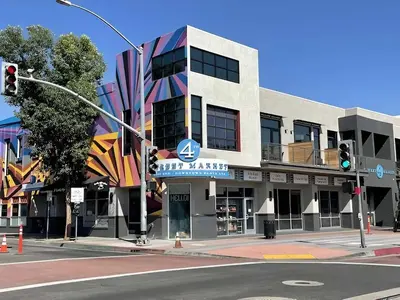 a building on the corner of a street with a traffic light at Luxe Deco Haven with Pool, Gym & Parking Close to Disneyland in Santa Ana