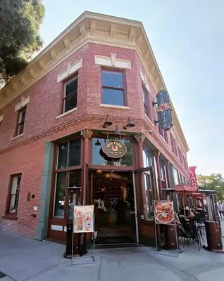 a red brick building with a pizza restaurant at Luxe Deco Haven with Pool, Gym & Parking Close to Disneyland in Santa Ana