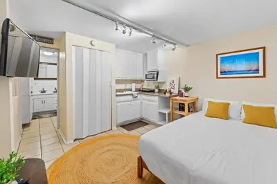 a bedroom with a large bed and a kitchen at Sea View, Sauna, Hot Tub, Beach Bikes, Stream in Ventura