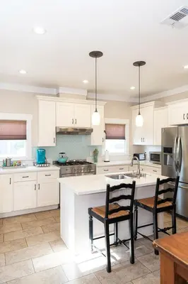 a kitchen with white cabinets and a table and chairs at Historic craftsman sleeps 9 3br2.5ba Disney 1mi in Anaheim