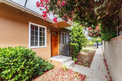 a house with a porch and a door with pink flowers at Santa Monica 2BD Home - 20 mins to LAX Airport! in Los Angeles