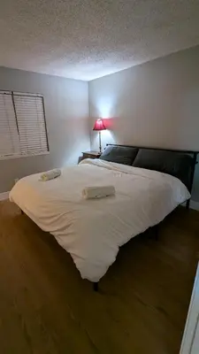 a large white bed in a room with a lamp at Serene home in Simi valley, CA in Simi Valley