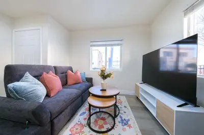 a living room with a couch and a flat screen tv at Modern Luxe Ensuite by USC Shared Living in Los Angeles
