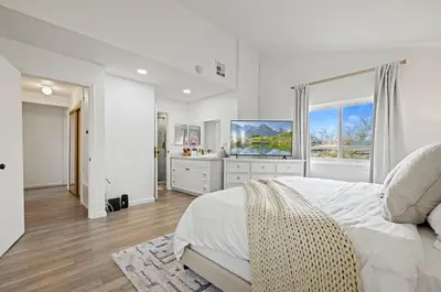 a white bedroom with a large bed and a television at Modern Private 3B-2BA Home and Spacious Yard in Lancaster
