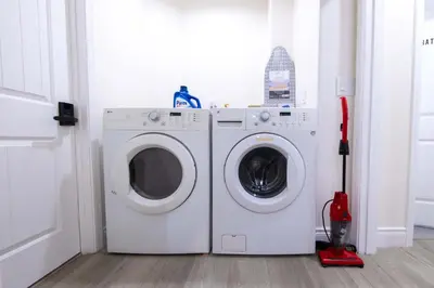 a washing machine and a mop in a laundry room at Modern Private Room in Shared Home -Walk to USC in Los Angeles