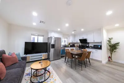 a living room with a couch and a table and a kitchen at Modern Private Room in Shared Home -Walk to USC in Los Angeles