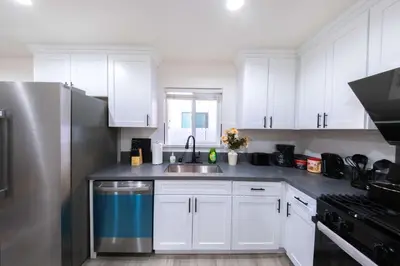 a kitchen with white cabinets and a stainless steel refrigerator at Modern Private Room in Shared Home -Walk to USC in Los Angeles